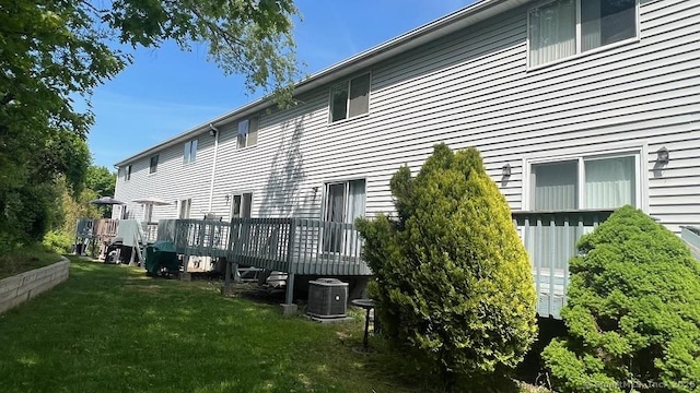 back of property featuring a yard and a deck