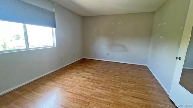 unfurnished room featuring wood finished floors and baseboards