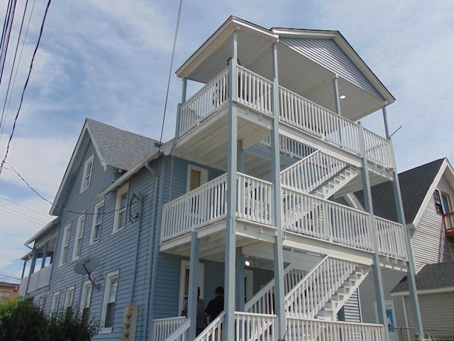 69 W Liberty St, Waterbury, CT 06706 - view of property exterior featuring a balcony, a shingled roof, and stairway