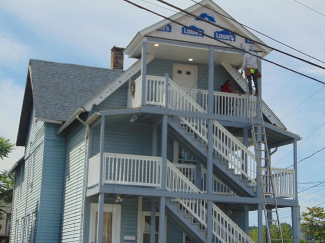69 W Liberty St, Waterbury, CT 06706 - view of front of property with stairs, a shingled roof, and a chimney