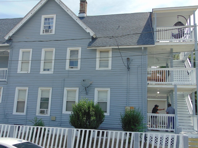 69 W Liberty St, Waterbury, CT 06706 - view of home's exterior with a chimney, roof with shingles, and stairs