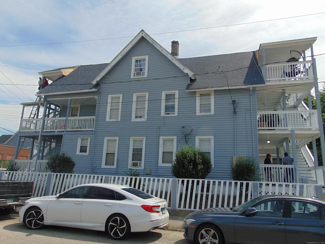 69 W Liberty St, Waterbury, CT 06706 - view of front of property with a chimney, a shingled roof, stairs, and a balcony
