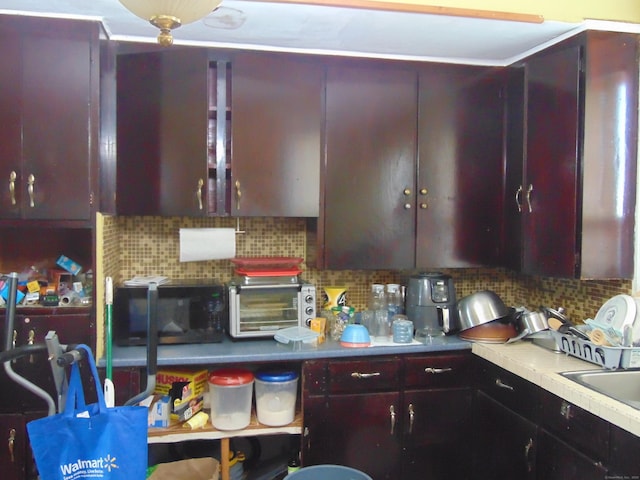 69 W Liberty St, Waterbury, CT 06706 - kitchen featuring tasteful backsplash, reddish brown cabinets, light countertops, and black microwave