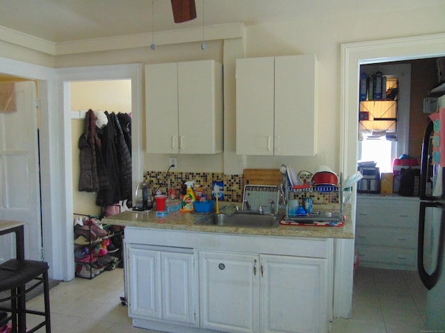 69 W Liberty St, Waterbury, CT 06706 - kitchen with light tile patterned floors, white cabinets, light countertops, freestanding refrigerator, and decorative backsplash