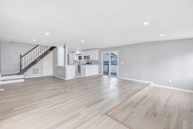 34 2nd Ave, East Haven, CT 06512 - unfurnished living room with light wood-style flooring, recessed lighting, and stairs