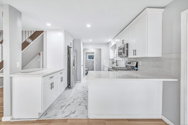 34 2nd Ave, East Haven, CT 06512 - kitchen featuring stainless steel appliances, recessed lighting, light countertops, light marble finish flooring, and a peninsula