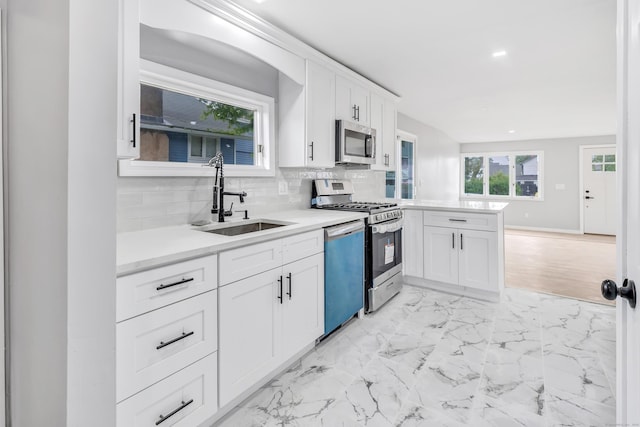 34 2nd Ave, East Haven, CT 06512 - kitchen with appliances with stainless steel finishes, a peninsula, light countertops, white cabinets, and backsplash