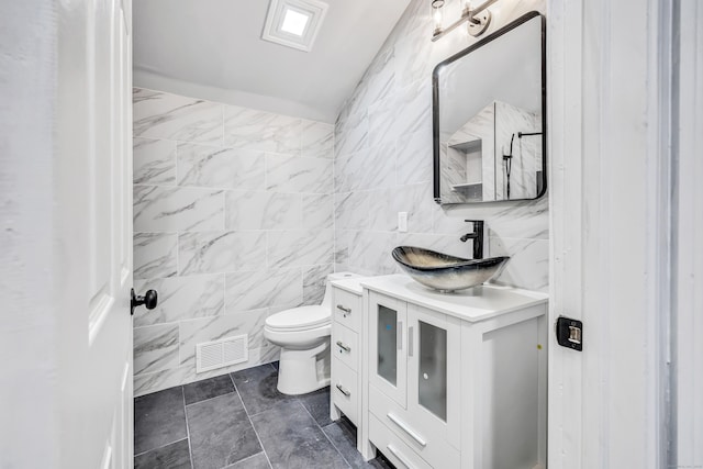 34 2nd Ave, East Haven, CT 06512 - bathroom featuring vanity, tile walls, and vaulted ceiling