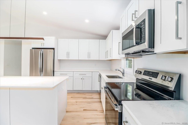36 Jotham Rd, New Milford, CT 06776 - kitchen featuring appliances with stainless steel finishes, light wood-type flooring, white cabinetry, lofted ceiling, and light countertops