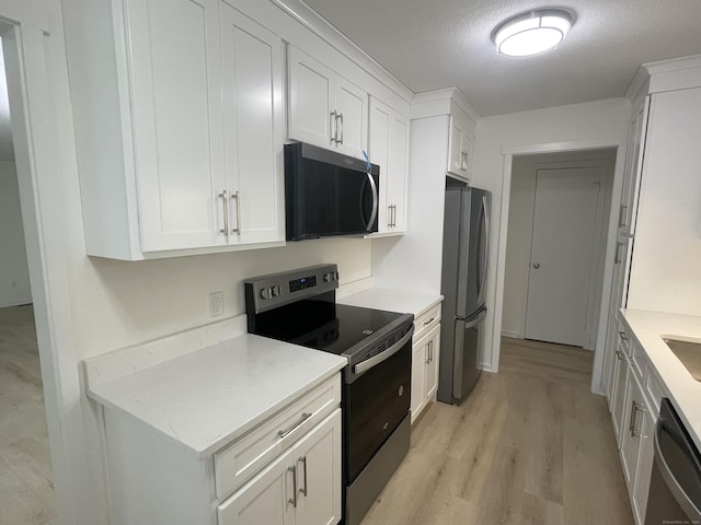277 Heritage Vlg Unit C, Southbury, CT 06488 - kitchen with appliances with stainless steel finishes, white cabinets, and light wood-style flooring