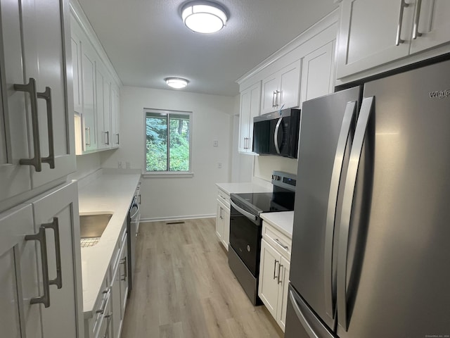 277 Heritage Vlg Unit C, Southbury, CT 06488 - kitchen featuring appliances with stainless steel finishes, light wood finished floors, light countertops, and white cabinetry