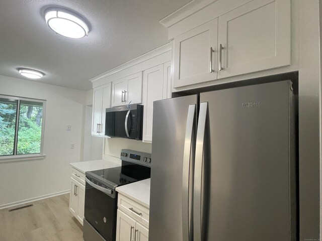 277 Heritage Vlg Unit C, Southbury, CT 06488 - kitchen featuring stainless steel appliances, light wood-style flooring, light countertops, and white cabinets
