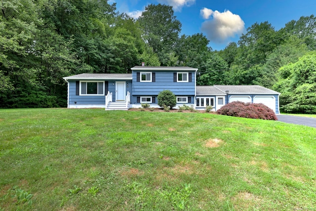 13 School St, Monroe, CT 06468 - tri-level home featuring asphalt driveway, a garage, a front lawn, and a wooded view