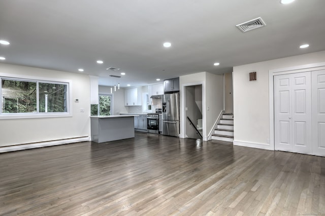 13 School St, Monroe, CT 06468 - unfurnished living room featuring baseboard heating, dark wood finished floors, recessed lighting, and stairs