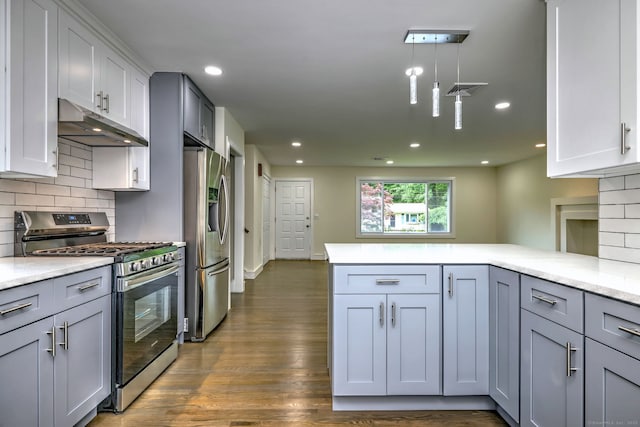 13 School St, Monroe, CT 06468 - kitchen featuring appliances with stainless steel finishes, under cabinet range hood, a peninsula, decorative backsplash, and dark wood-style flooring