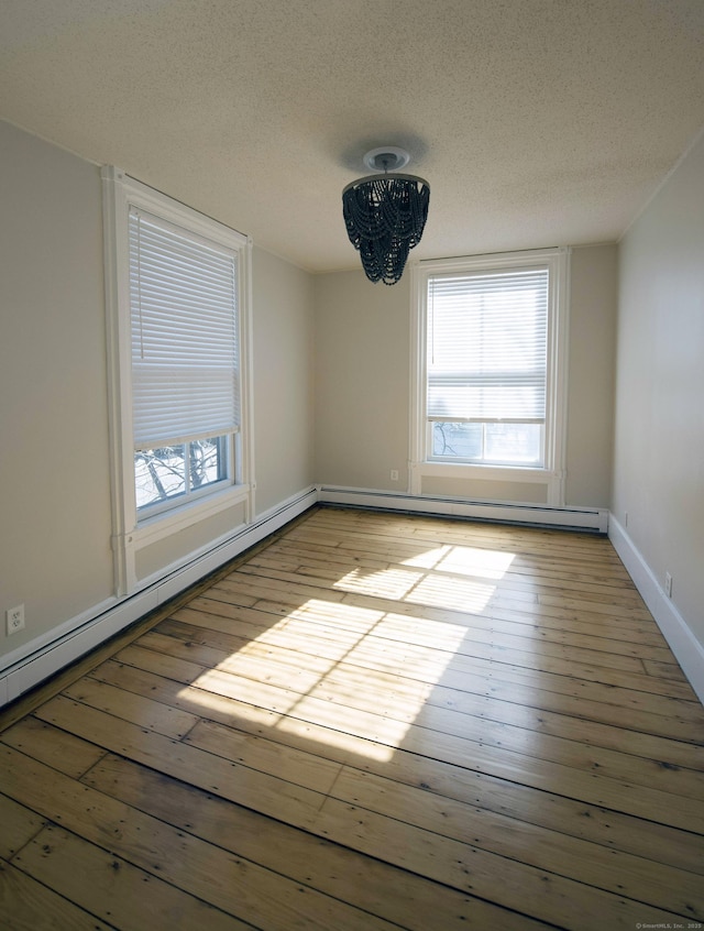 214 Broadway, Norwich, CT 06360 - unfurnished room with a textured ceiling, light wood-style floors, a baseboard heating unit, and a chandelier