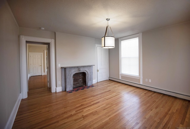214 Broadway, Norwich, CT 06360 - unfurnished living room with a baseboard heating unit, wood finished floors, and a premium fireplace