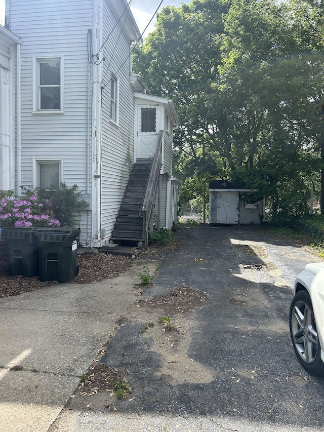 36 Boswell Ave, Norwich, CT 06360 - view of side of property with stairs, a storage unit, and asphalt driveway