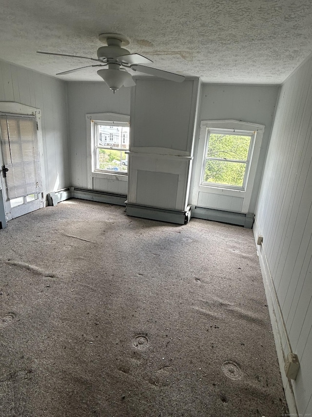 36 Boswell Ave, Norwich, CT 06360 - unfurnished living room featuring carpet flooring, plenty of natural light, a ceiling fan, a textured ceiling, and wooden walls