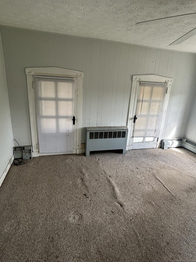 36 Boswell Ave, Norwich, CT 06360 - carpeted spare room featuring radiator, healthy amount of natural light, a textured ceiling, and wood walls