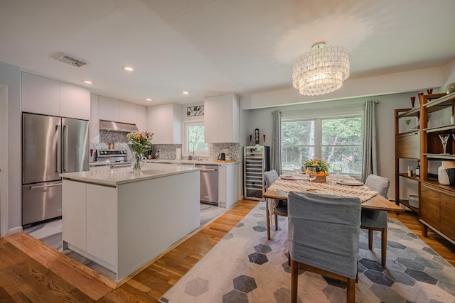 4 Northrop Rd, Woodbridge, CT 06525 - kitchen with stainless steel appliances, wine cooler, light wood-style floors, a chandelier, and light countertops