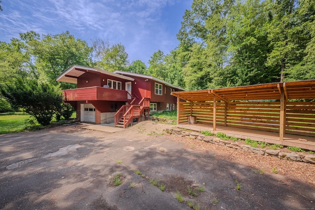 4 Northrop Rd, Woodbridge, CT 06525 - view of front of property with a wooden deck, driveway, stairs, and an attached garage