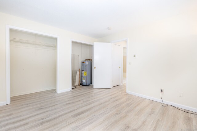430 Emmett St Apt L, Bristol, CT 06010 - unfurnished bedroom with water heater, two closets, and light wood-type flooring