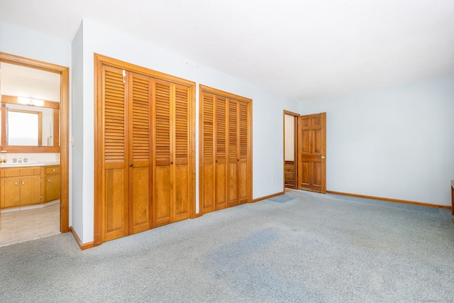 934 Jerome Ave, Bristol, CT 06010 - unfurnished bedroom featuring light carpet, two closets, and ensuite bath