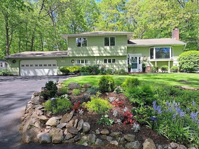 70 Bayne St, Norwalk, CT 06851 - split level home with a garage, a chimney, driveway, and a front lawn