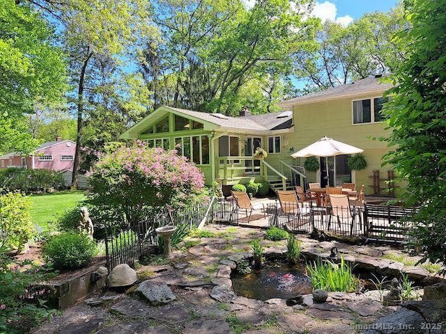 70 Bayne St, Norwalk, CT 06851 - back of house featuring a garden pond, a sunroom, and a patio area