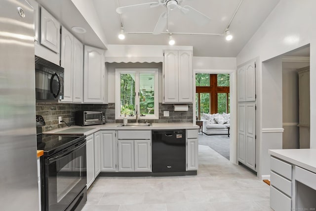 70 Bayne St, Norwalk, CT 06851 - kitchen with black appliances, track lighting, light countertops, tasteful backsplash, and lofted ceiling
