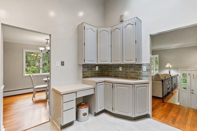 70 Bayne St, Norwalk, CT 06851 - kitchen featuring ornamental molding, light countertops, a baseboard radiator, backsplash, and healthy amount of natural light