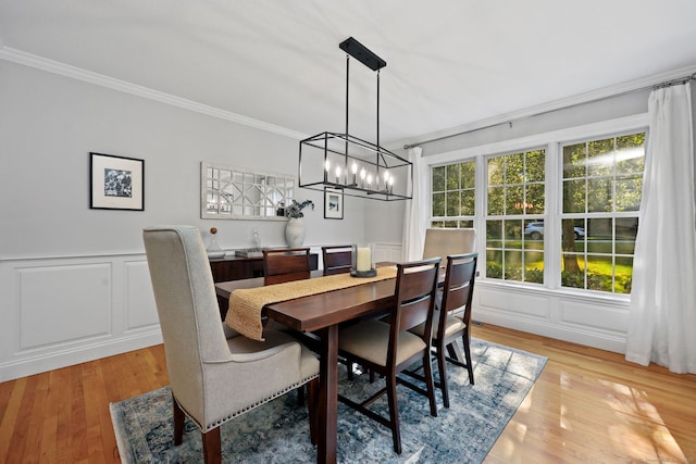 30 Poppy Ln, East Lyme, CT 06333 - dining room featuring crown molding, a decorative wall, a chandelier, light wood finished floors, and wainscoting