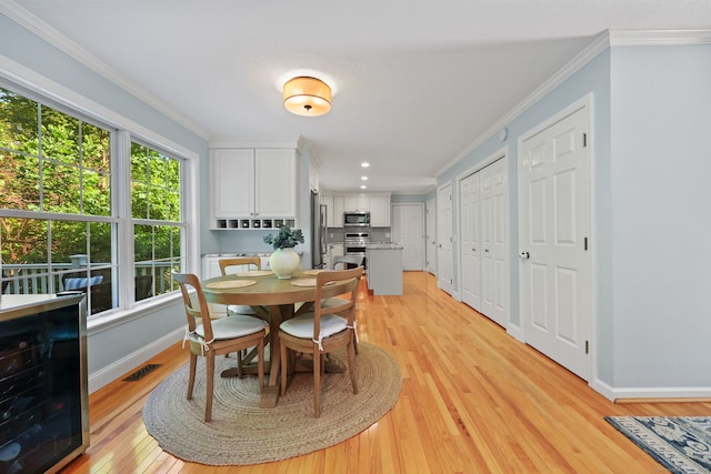 30 Poppy Ln, East Lyme, CT 06333 - dining room with wine cooler, ornamental molding, light wood-style flooring, and recessed lighting