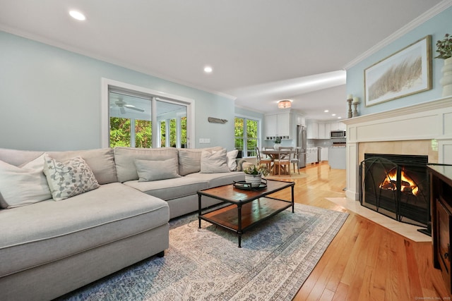 30 Poppy Ln, East Lyme, CT 06333 - living room with crown molding, recessed lighting, a tiled fireplace, and light wood finished floors