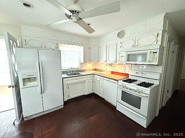 21 Eastwood Rd, Bridgeport, CT 06606 - kitchen featuring white appliances, a ceiling fan, light countertops, white cabinetry, and decorative backsplash