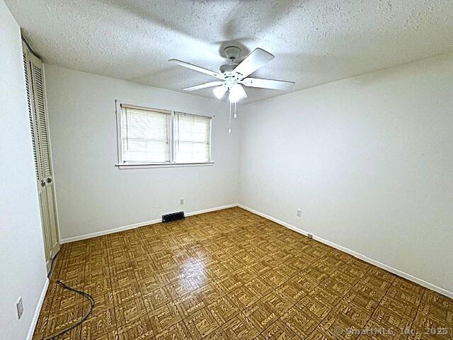 21 Eastwood Rd, Bridgeport, CT 06606 - unfurnished room with a ceiling fan and a textured ceiling