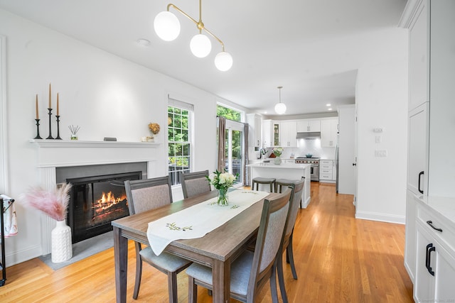 50 Buckingham Rd, Avon, CT 06001 - dining room with a glass covered fireplace and light wood-style flooring
