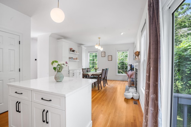 50 Buckingham Rd, Avon, CT 06001 - kitchen with light wood-style floors, open shelves, white cabinetry, pendant lighting, and a center island