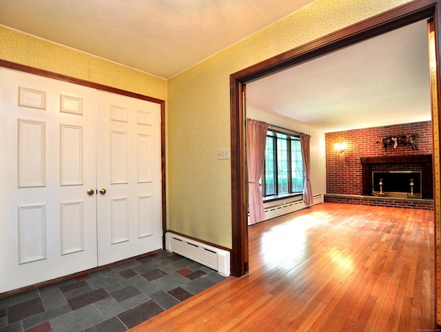 3 Carriage Dr, Canton, CT 06019 - entrance foyer with a baseboard radiator, a brick fireplace, and dark wood finished floors