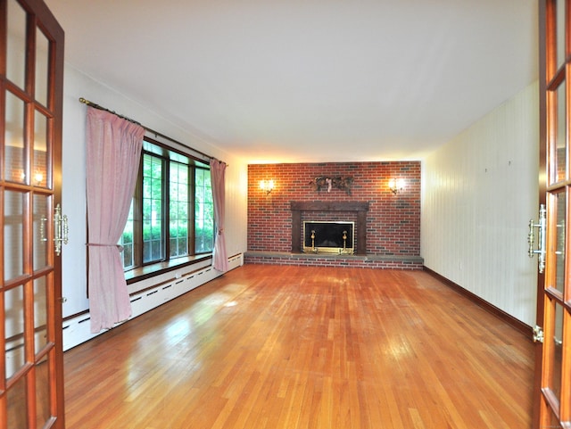 3 Carriage Dr, Canton, CT 06019 - unfurnished living room featuring wood finished floors, a brick fireplace, and a baseboard radiator