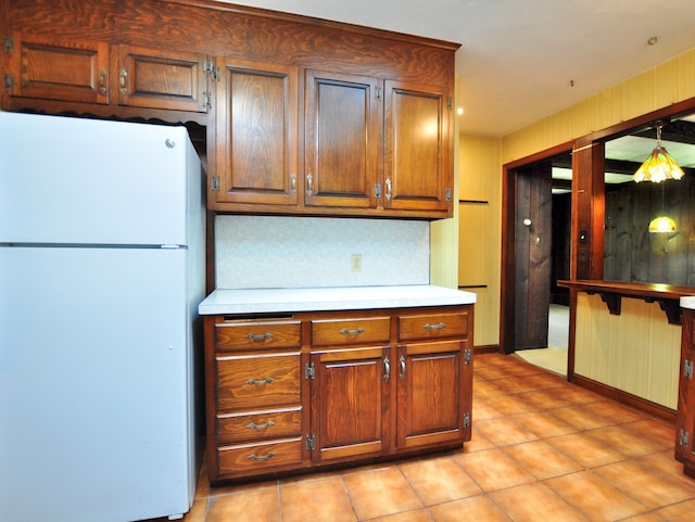 3 Carriage Dr, Canton, CT 06019 - kitchen with freestanding refrigerator, light countertops, light tile patterned floors, and brown cabinetry
