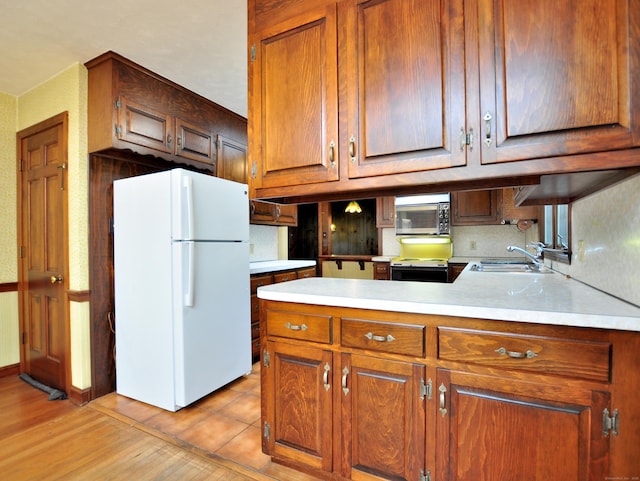 3 Carriage Dr, Canton, CT 06019 - kitchen featuring freestanding refrigerator, light wood-type flooring, light countertops, a peninsula, and stainless steel microwave