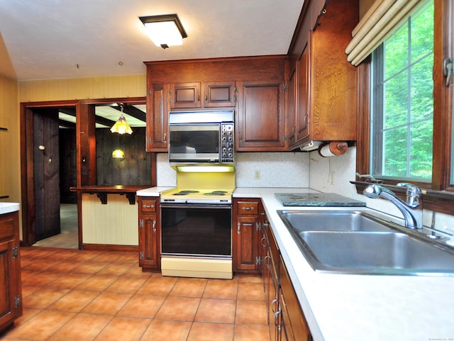 3 Carriage Dr, Canton, CT 06019 - kitchen with stainless steel microwave, electric stove, light countertops, decorative backsplash, and light tile patterned flooring