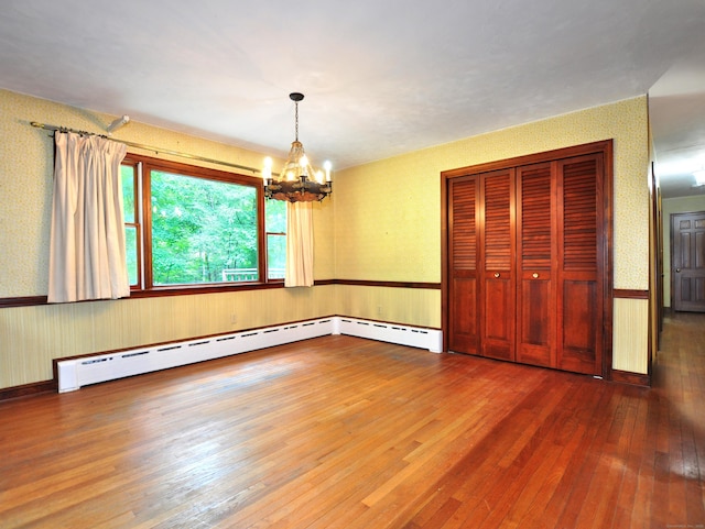 3 Carriage Dr, Canton, CT 06019 - unfurnished dining area with wallpapered walls, a wainscoted wall, hardwood / wood-style floors, a chandelier, and a baseboard radiator