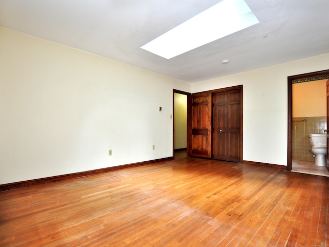 3 Carriage Dr, Canton, CT 06019 - unfurnished bedroom featuring a skylight, light wood-style flooring, a closet, and ensuite bath