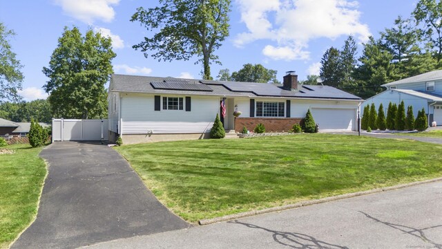 24 Pine Tree Rdg, Meriden, CT 06450 - view of front facade featuring a garage, roof mounted solar panels, a chimney, and asphalt driveway