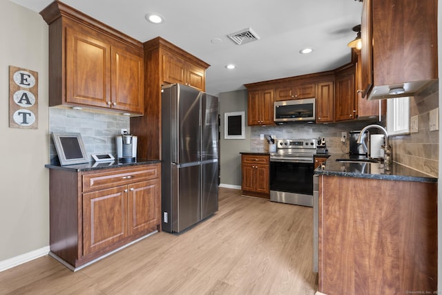 24 Pine Tree Rdg, Meriden, CT 06450 - kitchen with stainless steel appliances, light wood finished floors, tasteful backsplash, dark stone countertops, and recessed lighting