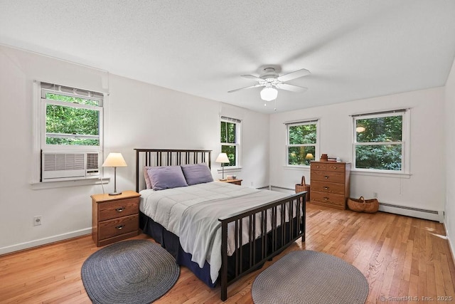 267 Jagger Ln, Hebron, CT 06248 - bedroom featuring baseboard heating, light wood-style floors, a ceiling fan, and a baseboard heating unit