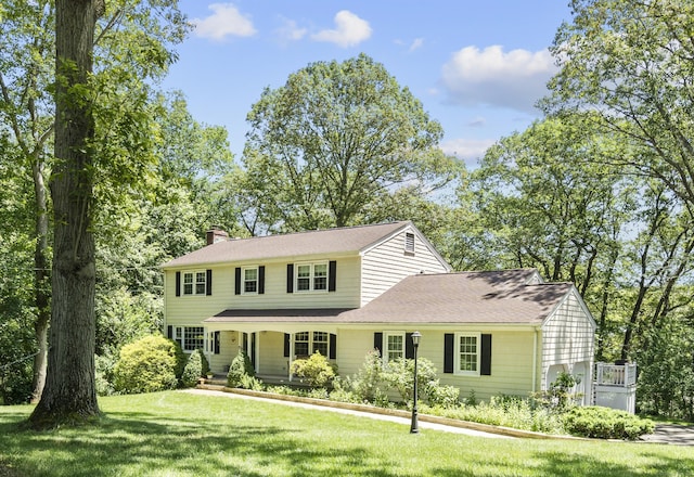 19 Buttercup Ln, Shelton, CT 06484 - view of front facade featuring a chimney, a front yard, and covered porch
